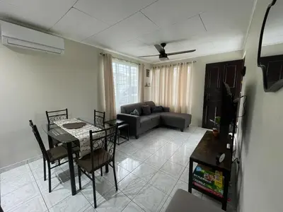 a living room with a couch and a table with chairs at Casa Luz Volcano View La Fortuna in Fortuna