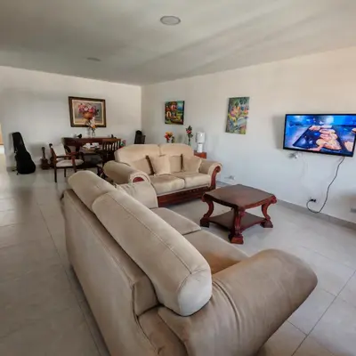 a living room with couches and a flat screen tv at Apartamentos Las Orquideas in San Pedro