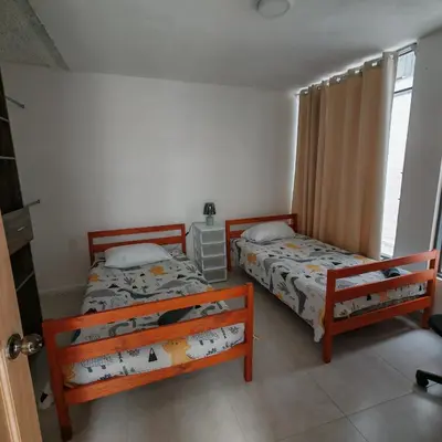 a bedroom with two beds and a window at Apartamentos Las Orquideas in San Pedro