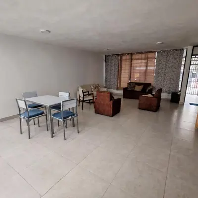 a living room with a table and chairs and a couch at Apartamentos Las Orquideas in San Pedro