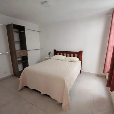 a bedroom with a bed in a white room at Apartamentos Las Orquideas in San Pedro