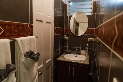 a bathroom with a sink and a mirror and towels at Beachfront Studio, Private Balcony with Ocean View in Tamarindo