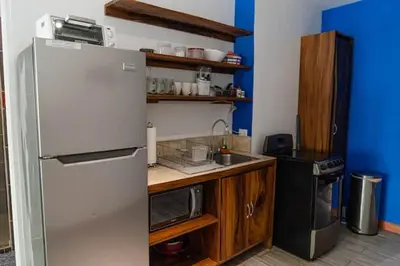 a kitchen with a refrigerator and a sink at Beachfront Studio, Private Balcony with Ocean View in Tamarindo