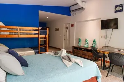 a bedroom with a bed and a bunk bed with a desk at Beachfront Studio, Private Balcony with Ocean View in Tamarindo