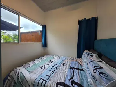 a bedroom with a bed and a window at Ocean Breeze at Life's a Beach in Uvita