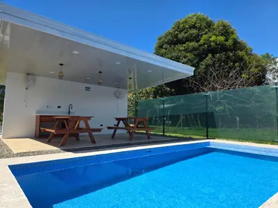 a house with a swimming pool and a table at Ocean Breeze at Life's a Beach in Uvita