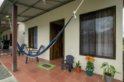 a hammock on the porch of a house at Villas Volcan Arenal in Fortuna