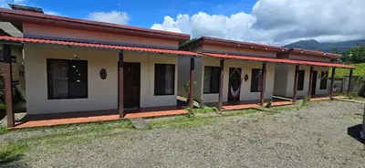 a row of houses in a field with mountains in the background at Villas Volcan Arenal in Fortuna