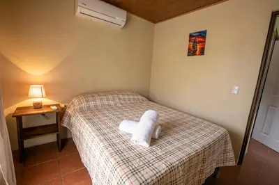 a room with a bed with a white towel on it at Villas Volcan Arenal in Fortuna