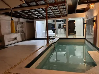 a swimming pool in a house with a living room at Family home in Cieneguita