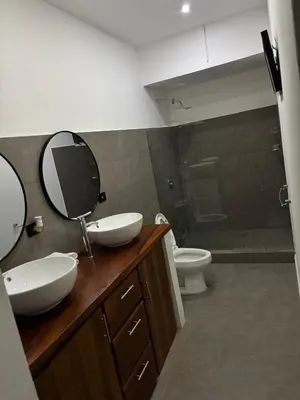 a bathroom with two sinks and a mirror and a toilet at Family home in Cieneguita