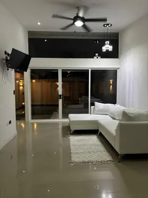 a living room with a white couch and a ceiling fan at Family home in Cieneguita