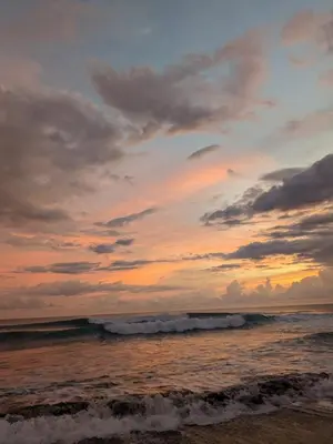 a sunset on the beach with the ocean at Mistico Beach Residence in Muñeco