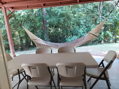 a table with chairs and a hammock in a house at Mistico Beach Residence in Muñeco