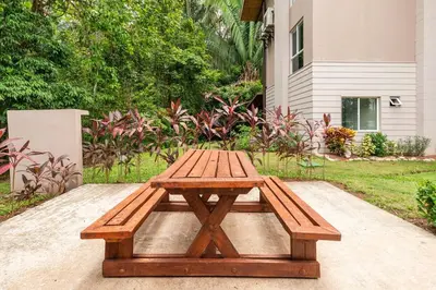 a wooden picnic table sitting on top of a sidewalk at Mistico Beach Residence in Muñeco