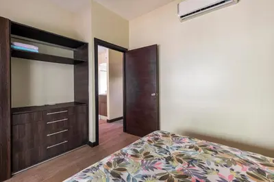 a bedroom with a bed and a dresser and a mirror at Mistico Beach Residence in Muñeco