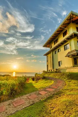 a building with a pathway next to the ocean at Ocean-Mountain views 2 Bdr, Villa Pelicano in Dominicalito