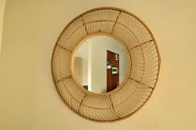 a mirror with a rattan frame hanging on a wall at Casa Aldama with private pool Near Playa Tamarindo in Santa Cruz