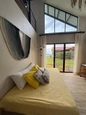 a bedroom with a bed with two pillows and a window at Chukita Loft en Villa Ron Dafa in Fraijanes