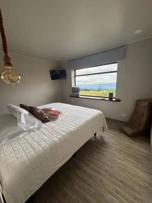 a bedroom with a bed and a large window at Chukita Loft en Villa Ron Dafa in Fraijanes