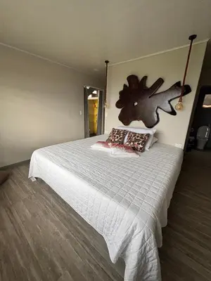 a bedroom with a large bed with a wooden floor at Chukita Loft en Villa Ron Dafa in Fraijanes