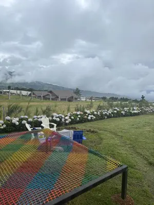 a colorful bird cage in a field with flowers at Chukita Loft en Villa Ron Dafa in Fraijanes