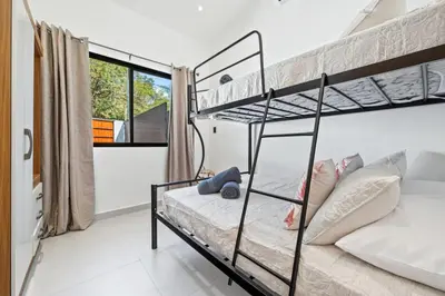 a bedroom with two bunk beds and a window at Casa 6 Palmas Jungle Hideaway with Private Pool in Tamarindo