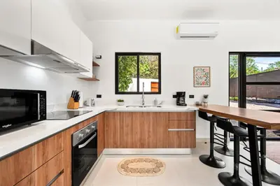a kitchen with wooden cabinets and a wooden table at Casa 6 Palmas Jungle Hideaway with Private Pool in Tamarindo