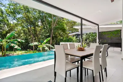 a dining room with a table and chairs and a pool at Casa 6 Palmas Jungle Hideaway with Private Pool in Tamarindo