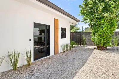 a white house with a large glass door at Casa 6 Palmas Jungle Hideaway with Private Pool in Tamarindo