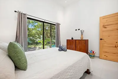 a bedroom with a bed and a large window at Casa 6 Palmas Jungle Hideaway with Private Pool in Tamarindo