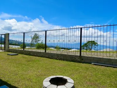 a view of the ocean behind a fence at Alma del Poas in Poasito