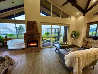 a large living room with a fireplace and a tub at Alma del Poas in Poasito