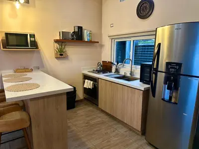 a kitchen with a stainless steel refrigerator and a sink at Alma del Poas in Poasito