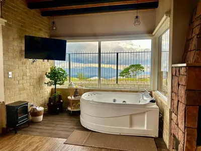 a large bath tub in a room with a large window at Alma del Poas in Poasito