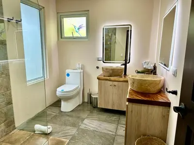 a bathroom with two sinks and a toilet at Alma del Poas in Poasito