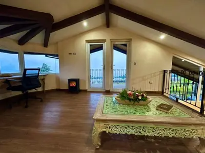 a large living room with a table with flowers on it at Alma del Poas in Poasito