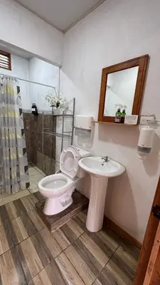 a bathroom with a toilet and a sink at Enchanted Valley CR in San Lorenzo