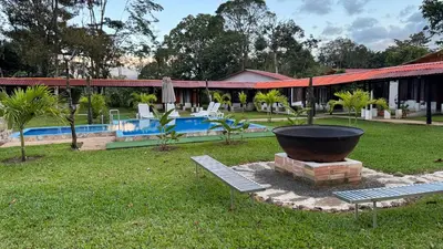 a garden with two benches and a large pot at Enchanted Valley CR in San Lorenzo