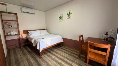 a small bedroom with a bed and a table at Enchanted Valley CR in San Lorenzo