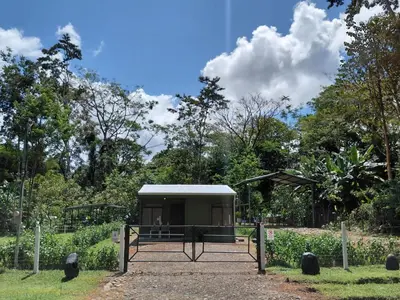 a small building with a gate in a park at Inmoexito Eco Tours in Upala
