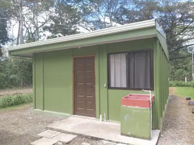 a green shed with a door and a red container at Inmoexito Eco Tours in Upala