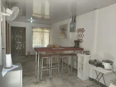 a kitchen with a table and stools in a room at Inmoexito Eco Tours in Upala