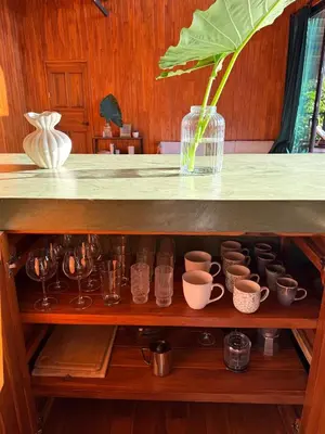a vase sitting on top of a wooden shelf with cups at Casa Canopy in Manzanillo
