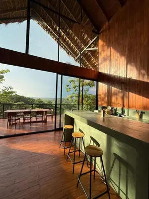 a kitchen with a bar and a table with chairs at Casa Canopy in Manzanillo