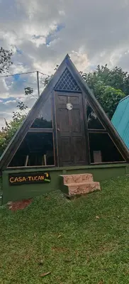 a small house with a door in the grass at Casa Tucán in Ángeles