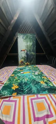 a bed with a colorful blanket on top of it at Casa Tucán in Ángeles