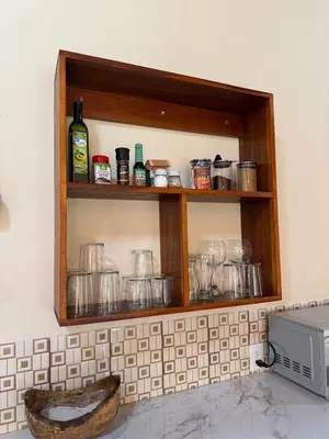 a kitchen with a shelf above a microwave at Casa Jardín Arenal in San Francisco