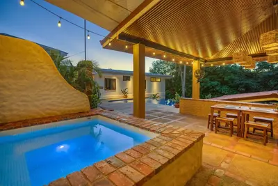 a swimming pool in a patio with a table at Walk to Beach - Hot Tub - Pool - Comfort & Space in Coco