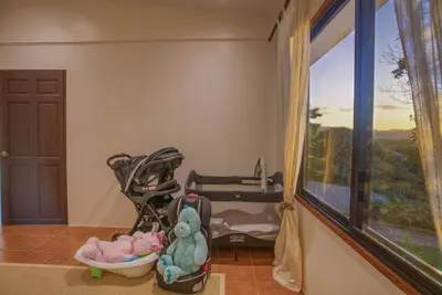 a baby stroller with stuffed animals sitting next to a window at Walk to Beach - Hot Tub - Pool - Comfort & Space in Coco